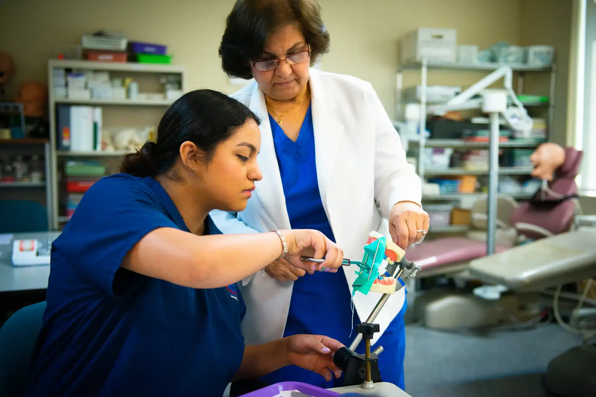 ACHT student practicing clinical dental assistant skills in a training lab