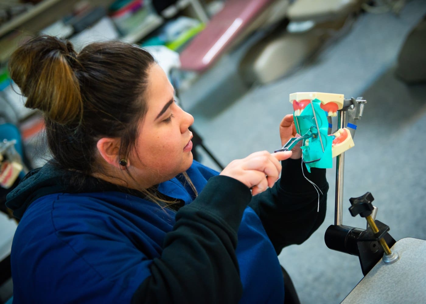 Healthcare student in a hands-on clinical learning environment preparing for dental assisting roles